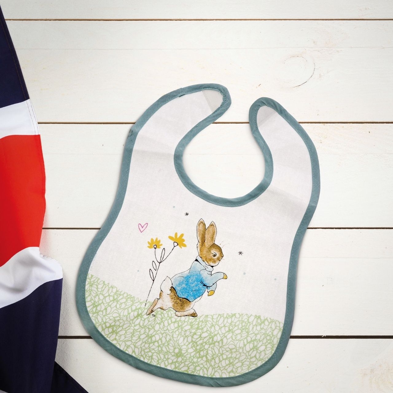 Beatrix Potter Peter Rabbit Children's Bib  Make mealtimes super fun with this beautiful Flopsy Bib. This is a fun and practical bib, has been perfectly detailed with original Flopsy illustrations, taken from the Beatrix Potter stories. This bib is not only easy to wear, but practical too with its wipeable coating.