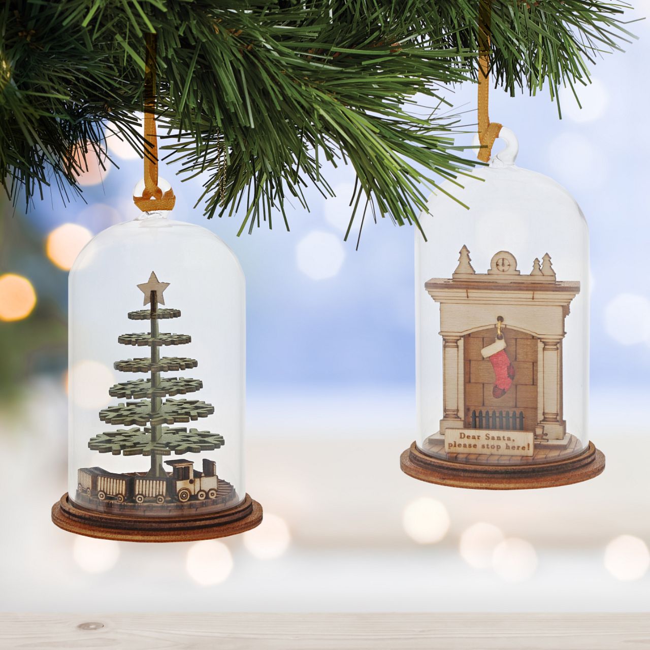 Christmas Childhood Memories Hanging Ornament Kloche  The Spirit of Christmas. A collection of delightful wooden decorations that capture the essence of that special time of year. This glass dome, Christmas decoration encases a Christmas tree, adorned with a nostalgic train set and ribbon to help hang off your Christmas tree.