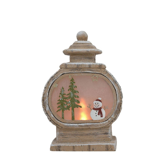 Introducing an LED Light Up Round Lantern Shaped Ornament with Snowman Scene. This charming item features a cheerful snowman and pine tree design that provides a heart-warming reminder of winter wonderlands.