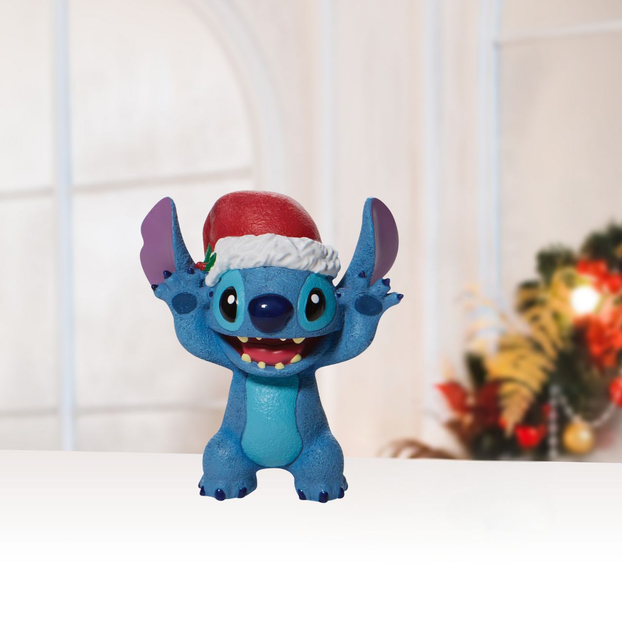 Department 56 Christmas Stitch Figurine  Everyone's favourite alien, Stitch, smiles jollily in his Santa hat this Christmas. With a bushel of holly tucked in his cap, he's ready for merry mischief. Hula through the holiday with Lilo's most festive friend and spread love to your Ohana.