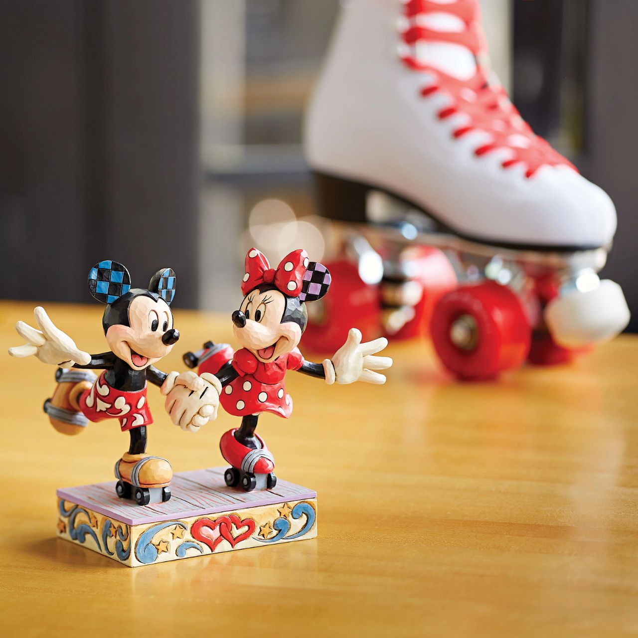 Introducing the newest addition to the Disney Traditions collection by Jim Shore - the Mickey and Minnie Mouse Roller Skating figurine] With exquisite attention to detail and impeccable craftsmanship, this high-quality piece is a must-have for any Disney fan and collector. Mickey and Minnie Mouse are arguably the most iconic couple in the Disney universe, and this figurine captures them in their element - roller skating together hand in hand.