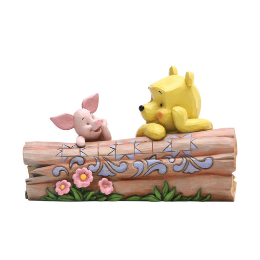 Jim Shore's Pooh and Piglet on a Log Figurine Truncated Conversation  Friends Winnie the Pooh and Piglet share a thoughtful moment together in the One Hundred Acre Wood. Folk art-inspired details add to the artisanal charm of this hand-painted figurine, sculpted from high-quality cast stone.