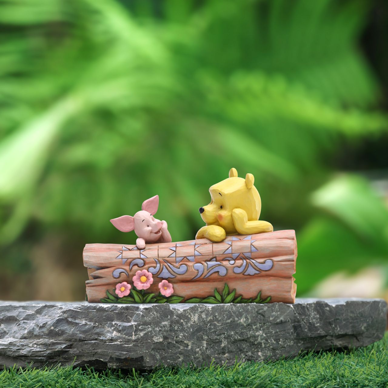 Jim Shore's Pooh and Piglet on a Log Figurine Truncated Conversation  Friends Winnie the Pooh and Piglet share a thoughtful moment together in the One Hundred Acre Wood. Folk art-inspired details add to the artisanal charm of this hand-painted figurine, sculpted from high-quality cast stone.