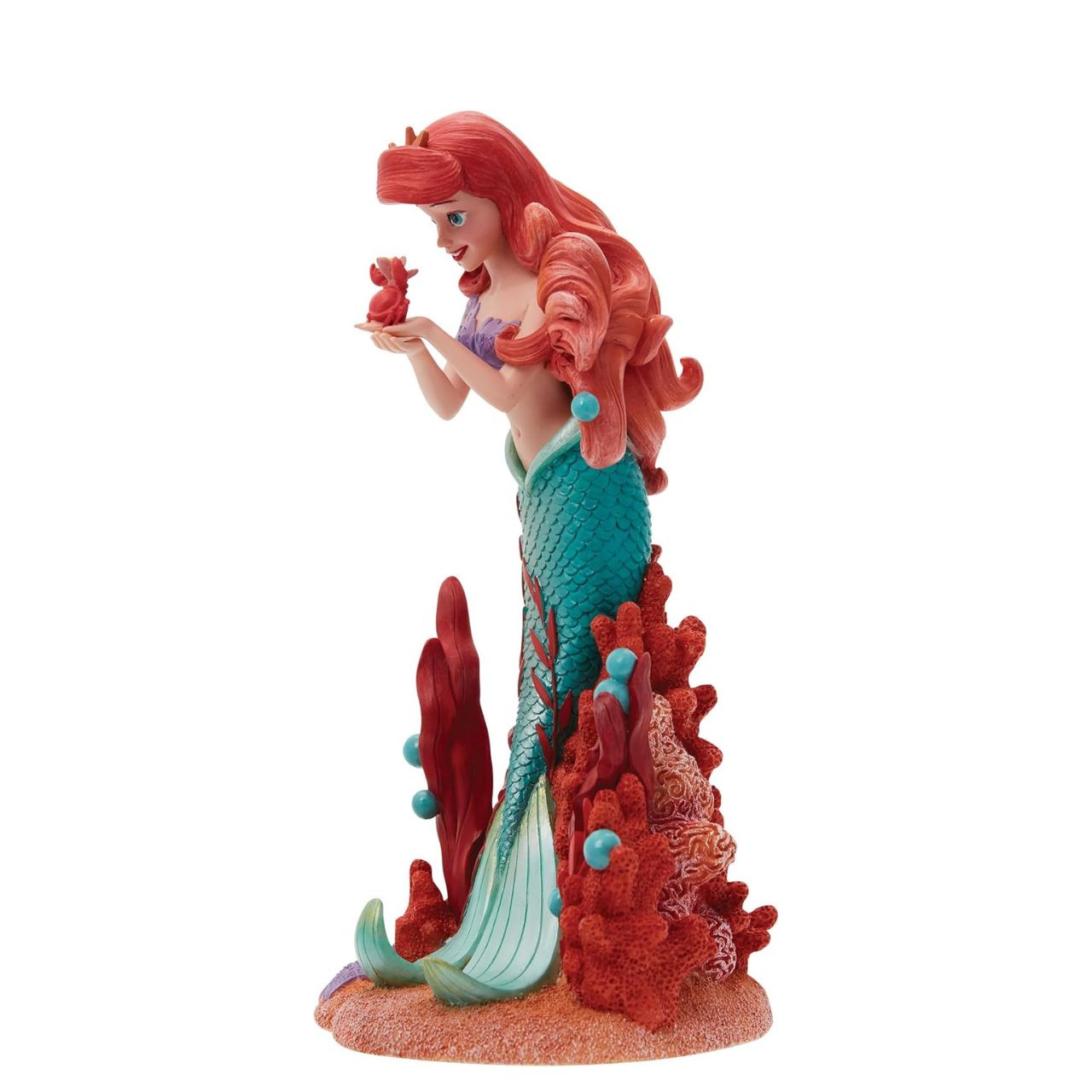 Ariel joins the Disney Showcase Botanical collection in honour of the film's 35th Anniversary featuring sea florals and coral (which is the 35th Anniversary gift). Ariel holds a small Sabastian in her delicate hands as she listens intently to his story. A vibrant base of coral, sand and rising bubbles encapsulates the underwater princess.