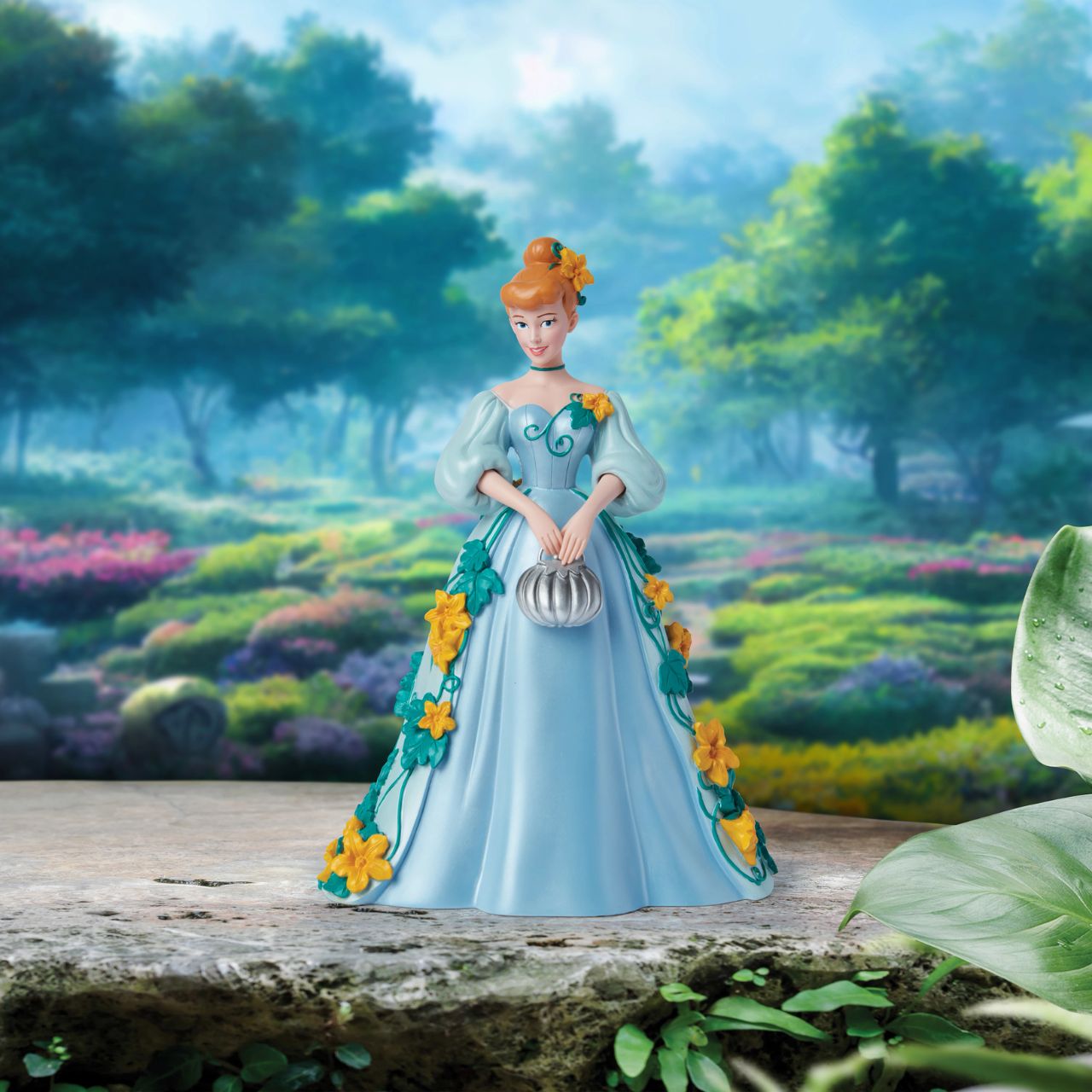 Part of the Disney Showcase Botanical collection, the Botanical Cinderella figurine sees Disney's iconic princess in her trademark blue ball gown adorned with bright yellow flowers and swirling green vines. Holding her silver pumpkin shaped handbag, she's ready to meet her Prince Charming.