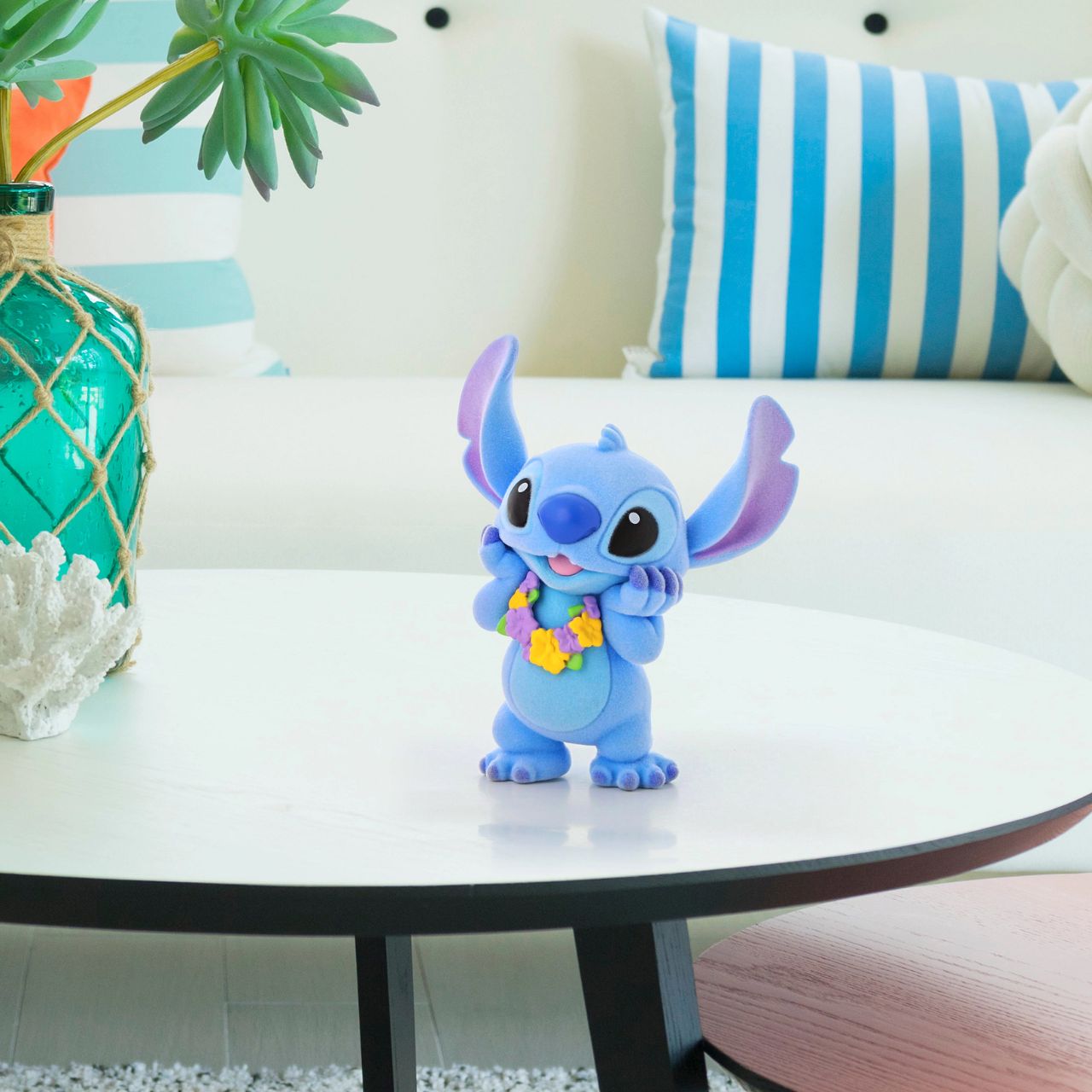 This super cute Stitch is dressed in a pretty lei, ready to get in the party mood. What makes him even more special is that this Stitch is flocked, which makes him fuzzy to touch. Disney's favourite alien is the perfect addition to any collection and this one is sure to make an impact wherever he goes. Comes in fully branded window box.