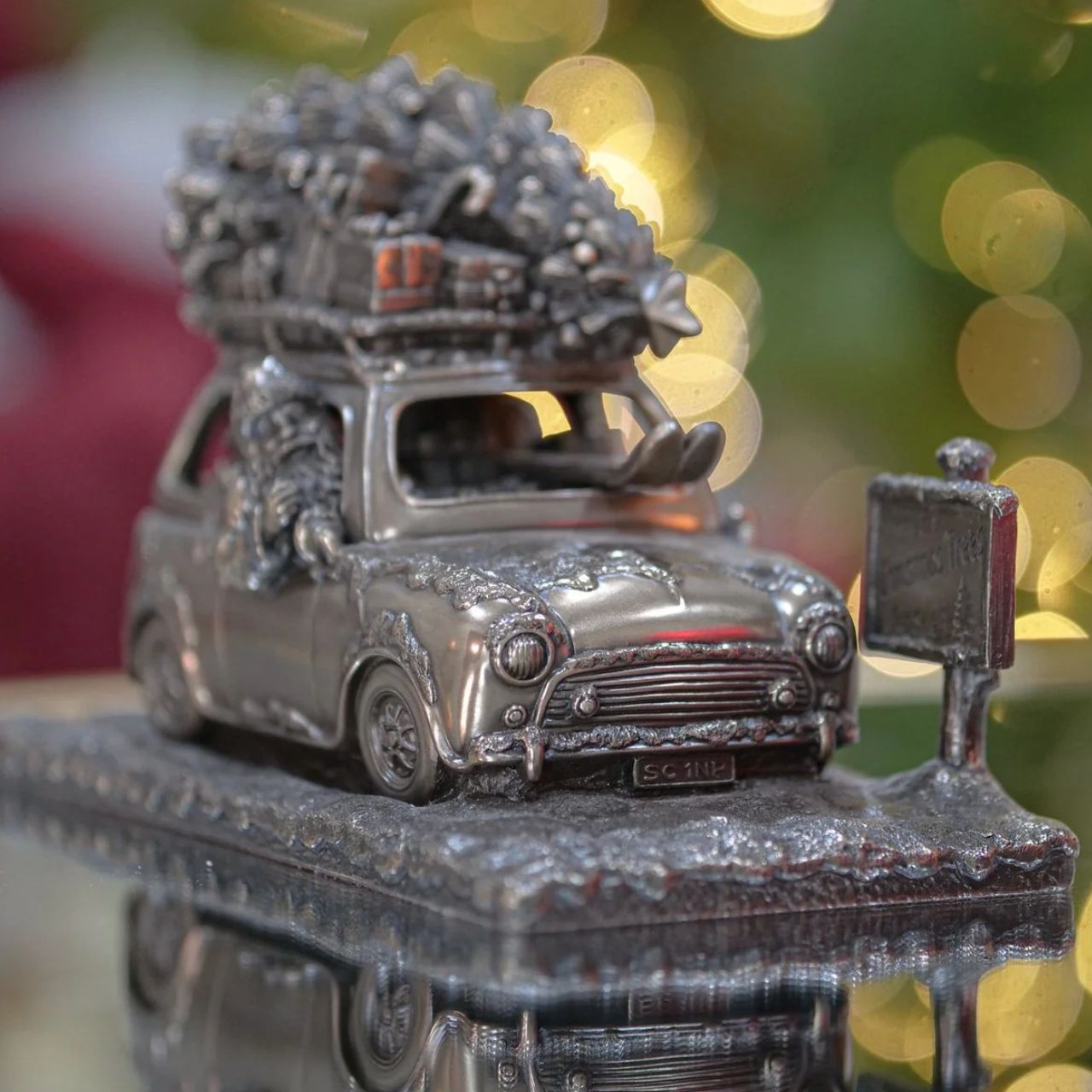 A stunning ornament that is sure to bring festive cheer to your home. This sculpture depicts a Santa driving a car to the north pole with a Christmas tree on the roof.