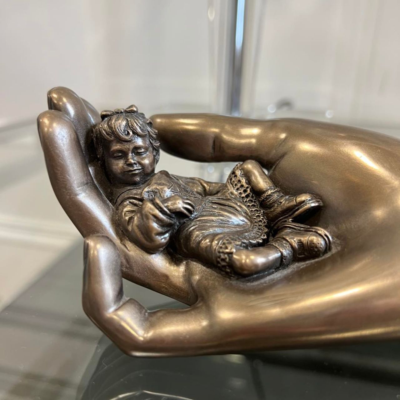 Beautifully crafted in cold cast bronze this wonderful baby figurine from the craftsmen of Genesis Fine Arts depicts the sleeping baby boy carefully curled up in a mothers caring hand.