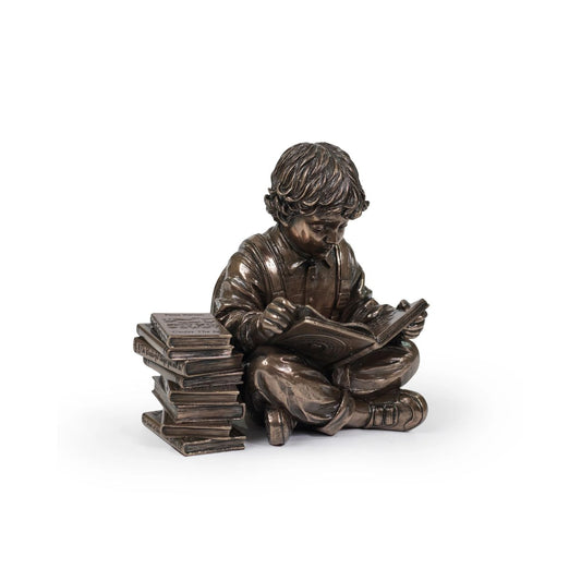 Discover a scene that resonates with the tranquillity of learning, a young boy engrossed in a world of imagination, sitting beside a stack of cherished books.