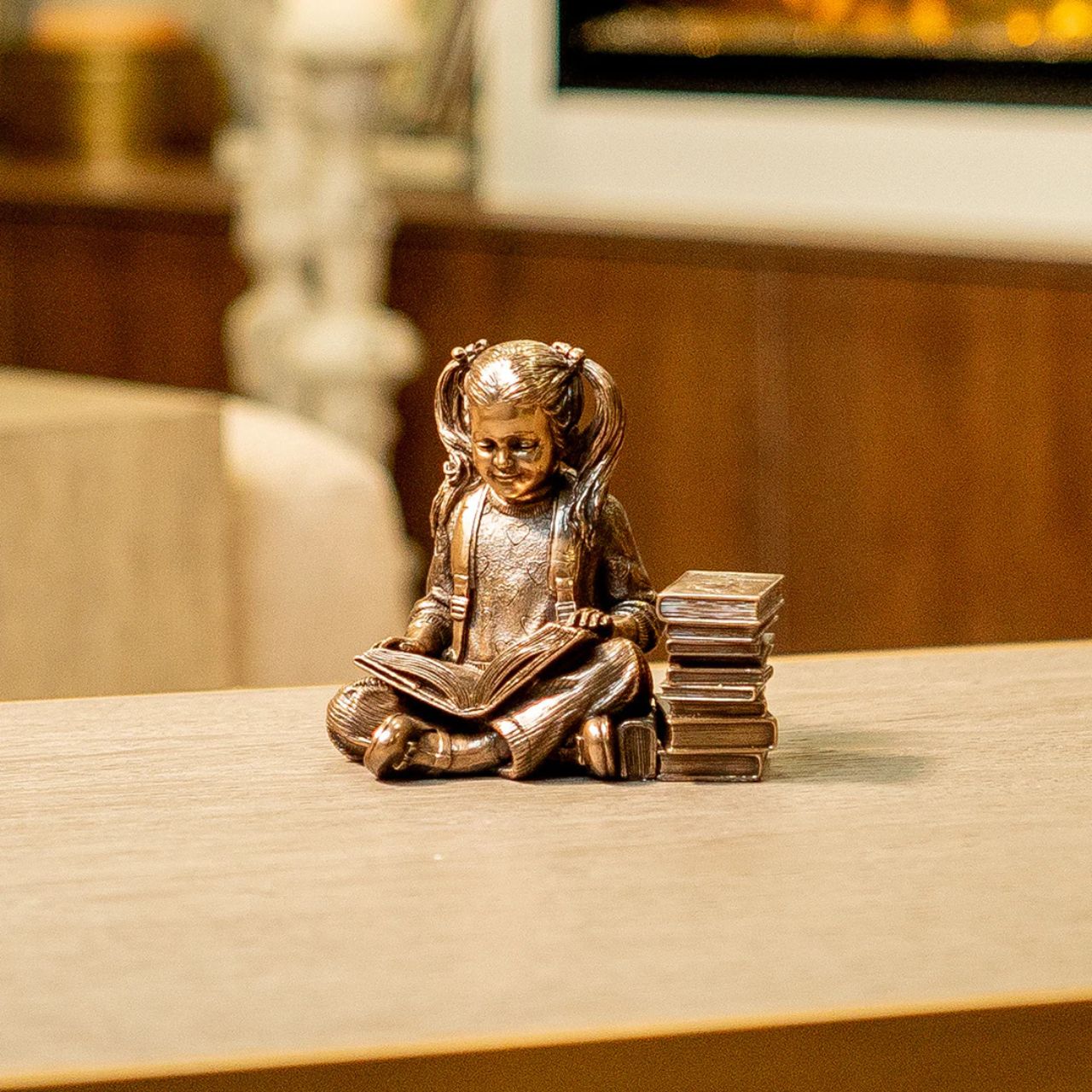 Elevate the essence of literary charm with this enchanting small sculpture a portrayal of a young girl immersed in the world of imagination.