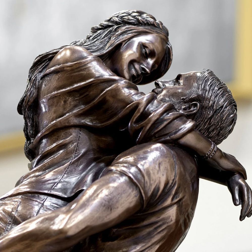 The Promise by Genesis Ireland  A beautiful bronze coloured statue of a couple in a loving embrace.