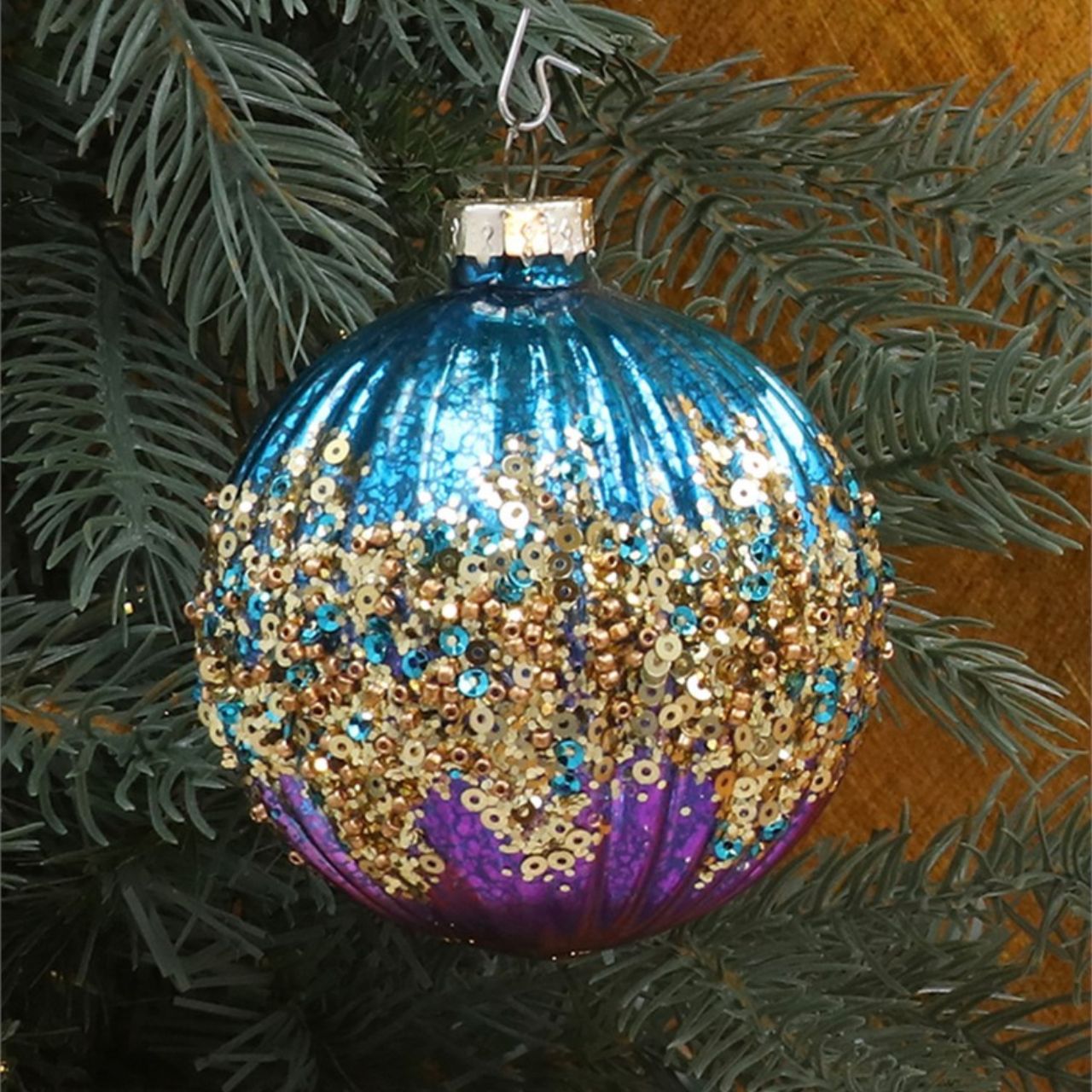 These Gisela Graham Christmas Baubles feature a ribbed design in a vibrant purple and turquoise colour, with a touch of sparkle. Add a festive touch to your tree with these elegant baubles, perfect for the holiday season. Made with high-quality materials, these baubles are both durable and visually appealing.