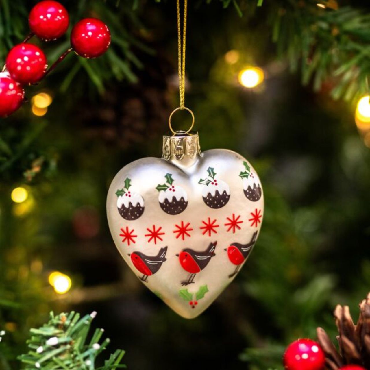 Experience the joy of Christmas with these stunning Gisela Graham Christmas Baubles. The elegant matte white heart design features a charming pudding robin and stars, adding a festive touch to any tree. Spread holiday cheer and make memories with these beautiful ornaments.