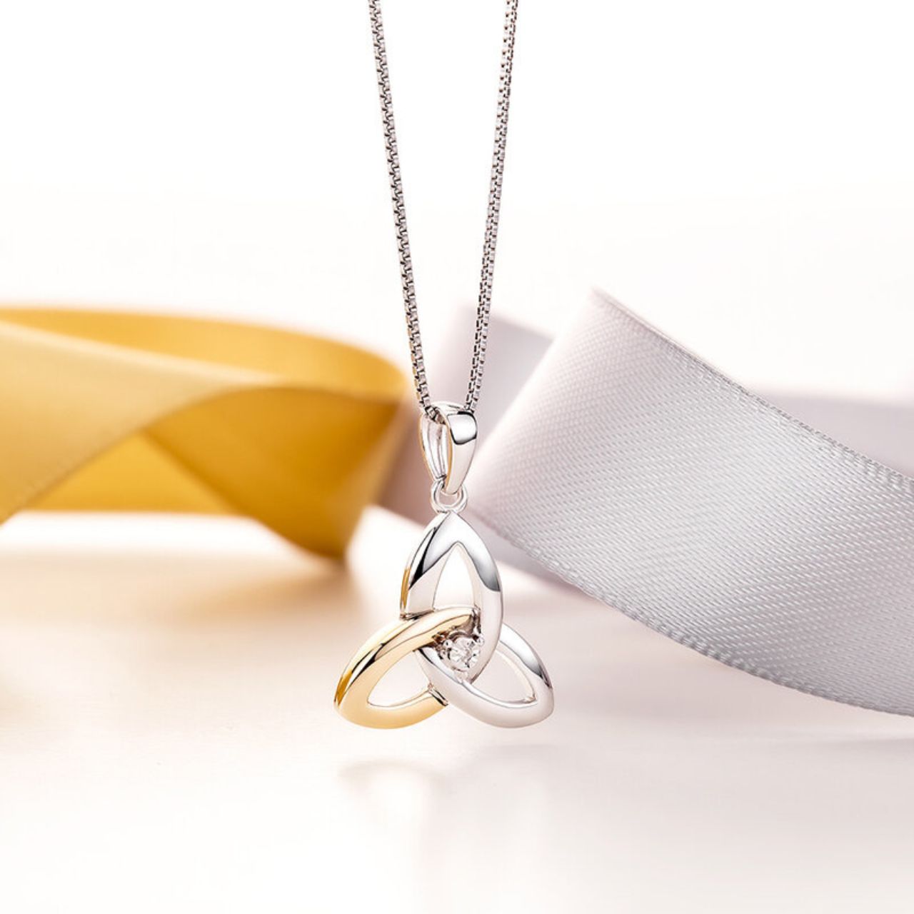 Our beautiful Trinity Knot necklace has been crafted in sterling silver and 10 karat gold, and embellished with a stunning diamond gemstone. The Trinity Knot symbolises eternal love, with no beginning and no end. This piece has been Irish hallmarked in Dublin Castle and would make a perfect gift for someone special.