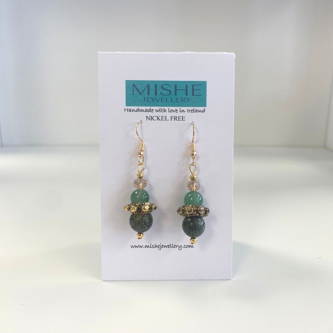 This pair of earrings features African Turquoise gemstones combined with Aventurine gemstones and champagne coloured Crystal, teamed with a decorative Brass ring.