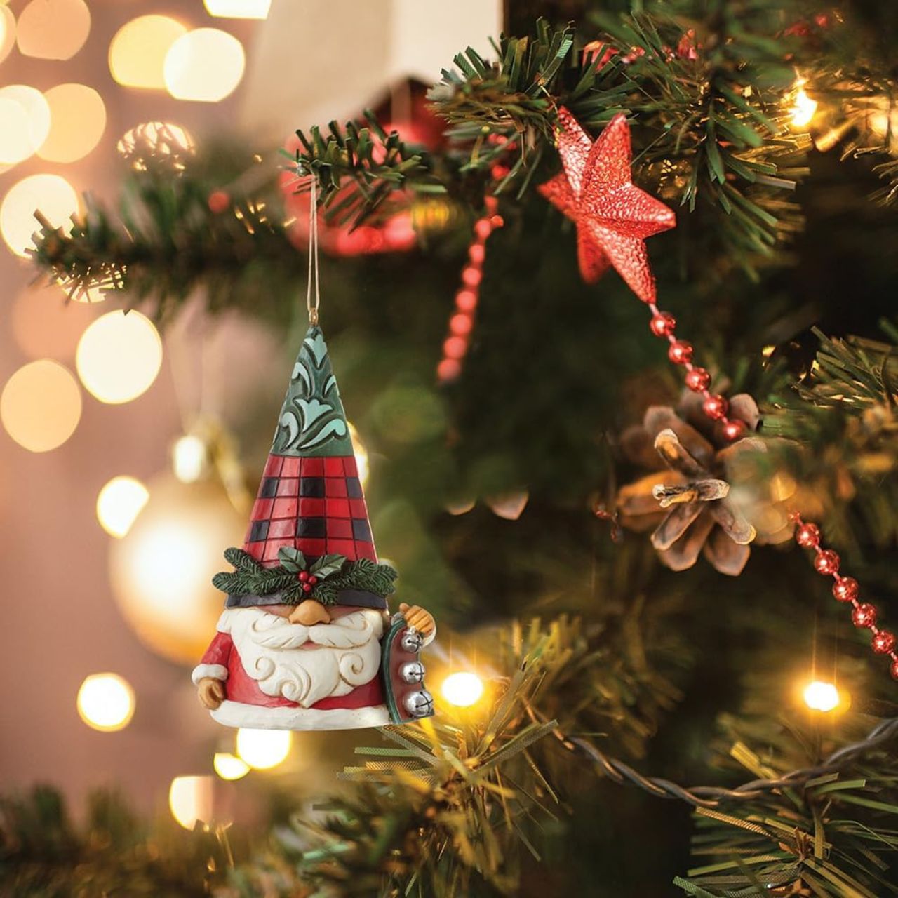 No one knows gnomes like Jim Shore! Creating yet another gnome, Jim has put a playful spin on Christmas. This Highland Glen holiday gnome ornament wears a plaid red hat topped in green rosemaling and belted in holly. He holds a ring of jingle bells.