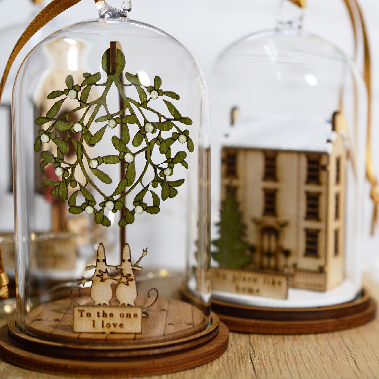 Home for Christmas Hanging Ornament  The Spirit of Christmas. A collection of delightful wooden decorations that capture the essence of that special time of year. This glass dome, Christmas decoration encases a magical house, adorned with a Christmas tree and ribbon to help hang off your Christmas tree.