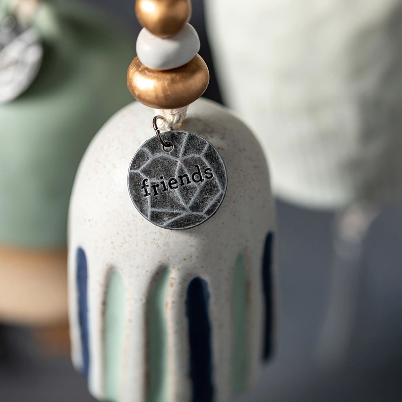 Give beauty and relaxation with our Inspired Bells collection, a selection of artisan bells in soft, serene colours with soothing, gentle rings bearing sentiments of faith and love. Our Inspired Bell - Friends is a ceramic indoor/outdoor bell in white with blue and green stripes. The sentiment on the bell reads, "Friends." You can give this calming memory bell as a birthday, Christmas anytime, rough times, self-care, or hospital gift.