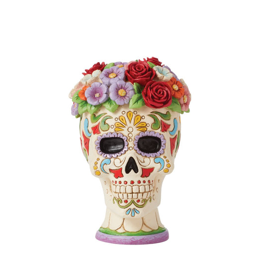 This colourful skull figurine from Jim Shore celebrates the Day of the Dead with bright colour and mesmerizing pattern. The inspired sugar skull wears a crown of flowers. With a toothy smile, enjoy the holiday with style.