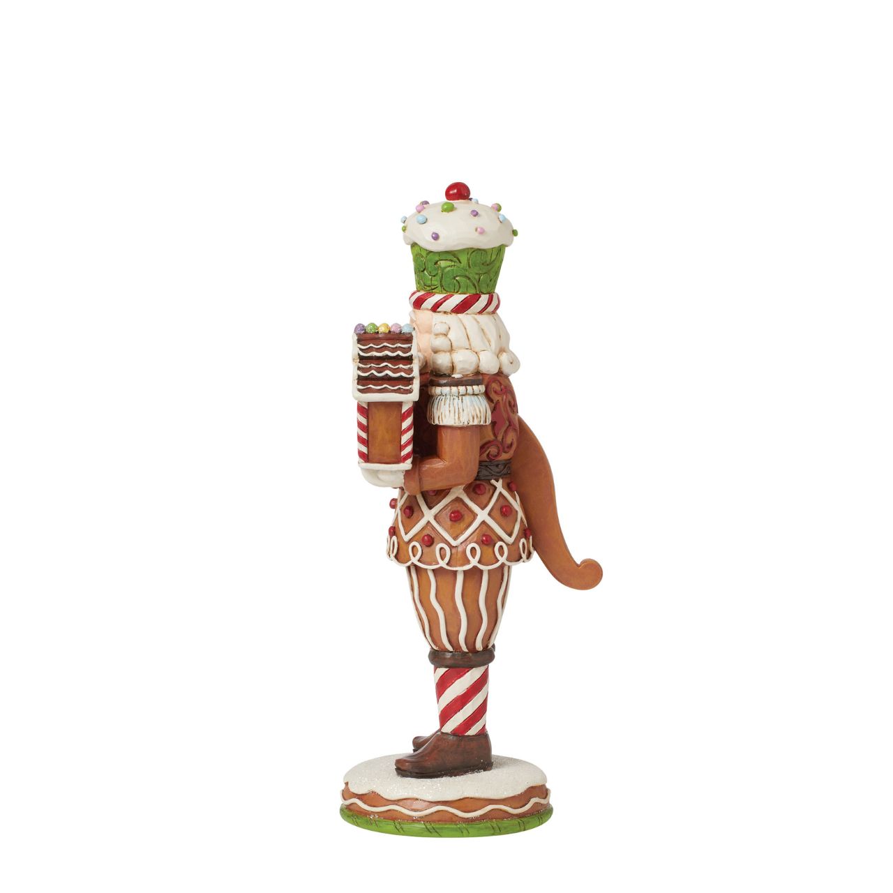 This Santa nutcracker from Jim Shore wears a coat modelled off candy canes. With stripes, frosting rosemaling, and sprinkles, Santa's uniform is buttoned with a peppermint candy. With a cupcake cap and rosy cheeks, nutcracker Santa holds gingerbread.