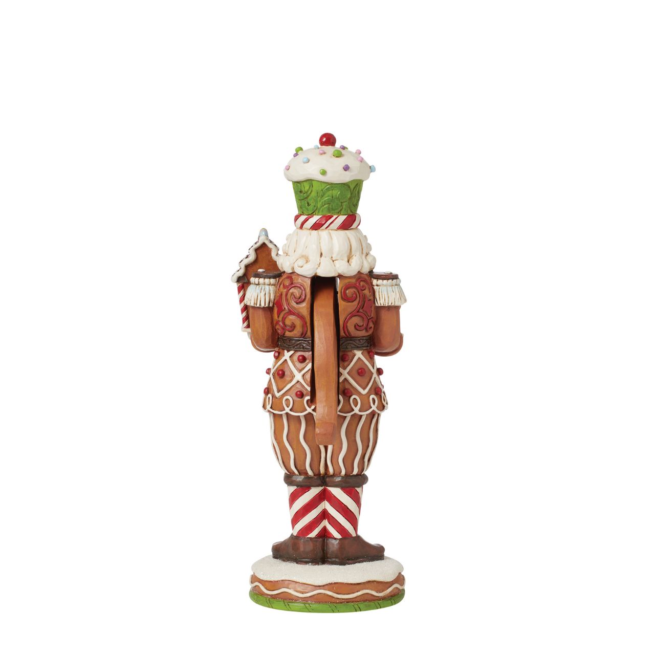 This Santa nutcracker from Jim Shore wears a coat modelled off candy canes. With stripes, frosting rosemaling, and sprinkles, Santa's uniform is buttoned with a peppermint candy. With a cupcake cap and rosy cheeks, nutcracker Santa holds gingerbread.