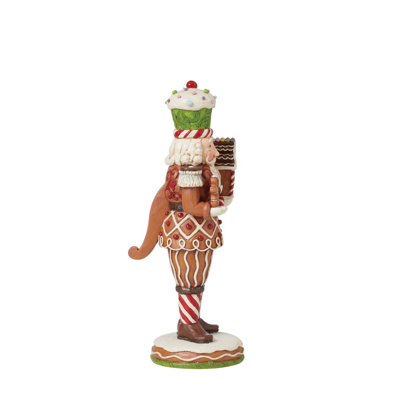 This Santa nutcracker from Jim Shore wears a coat modelled off candy canes. With stripes, frosting rosemaling, and sprinkles, Santa's uniform is buttoned with a peppermint candy. With a cupcake cap and rosy cheeks, nutcracker Santa holds gingerbread.