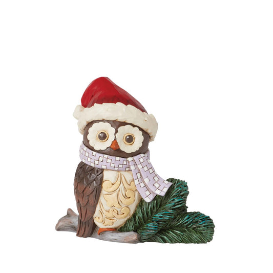 This miniature owl figurine wears a patchwork blue scarf with a Santa hat. With wide eyes and sweet expression, the little owl perches near pine needles with a rosemaling bust. This charming Jim Shore figurine is sure to make your holidays a hoot!