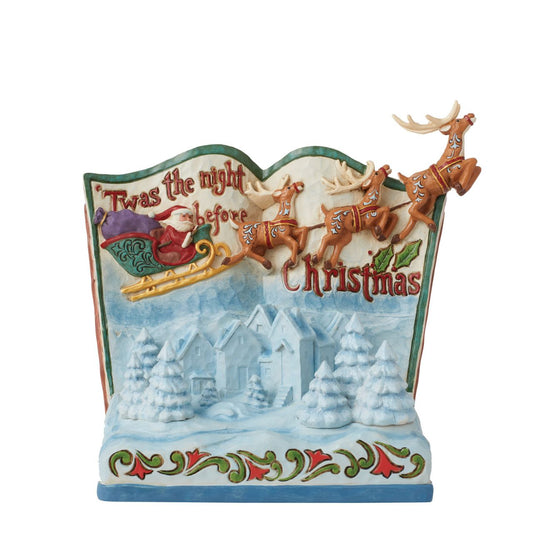 In this beautiful hand-painted storybook scene, Santa and his Reindeers are flying through the night sky to deliver Christmas presents on Christmas Eve. Designed by award winning artists Jim Shore, this features his iconic rosemaling and showcasing influences from traditional quilt making patterns.