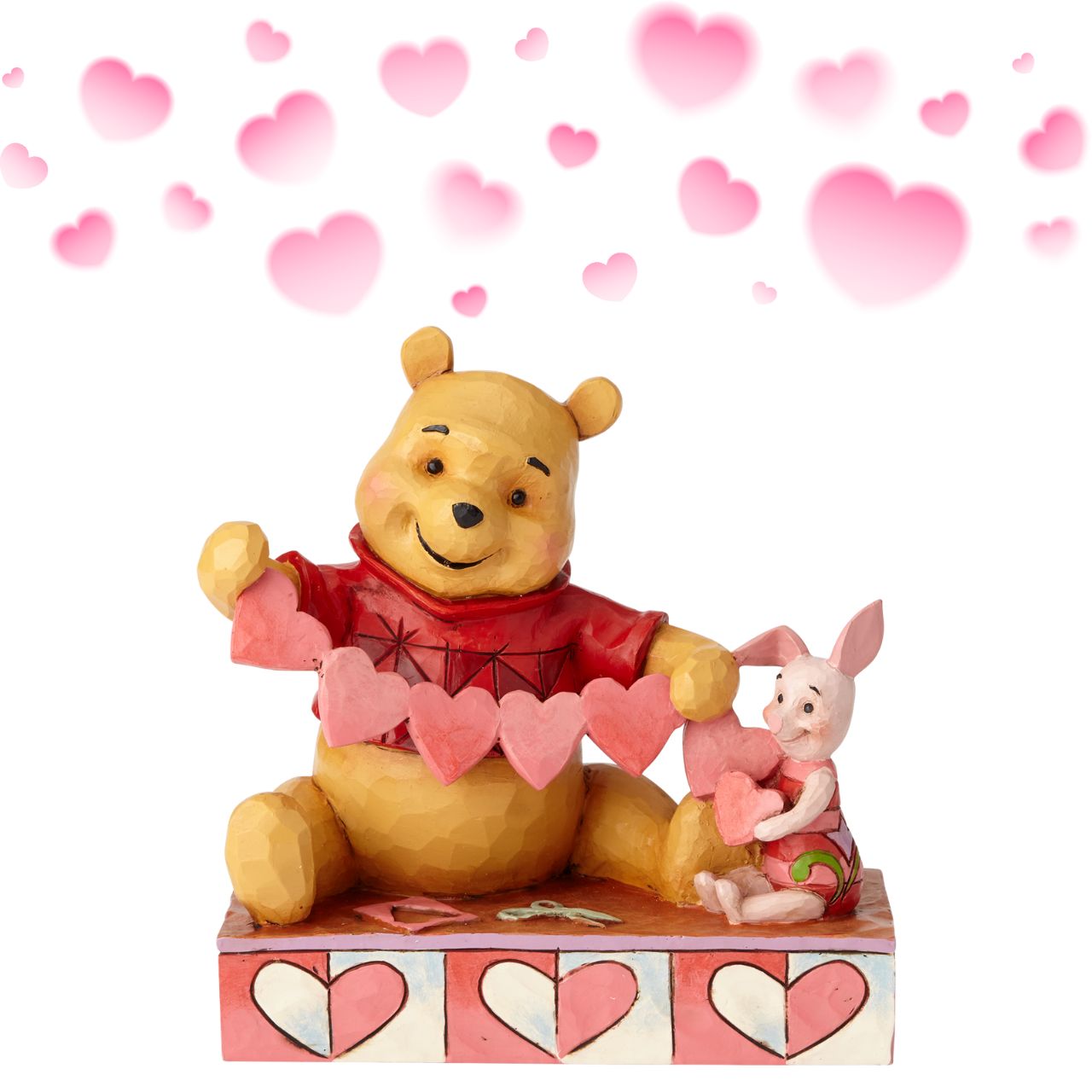 Disney Traditions Handmade Valentines Pooh and Piglet Figurine  Will you be Pooh's Valentine? Piglet and Winnie the Pooh sit close beside each other as they trace and snip a handmade garland of hearts. Folk art-inspired details add to the artisanal charm of this hand-painted figurine, sculpted from high-quality cast stone.