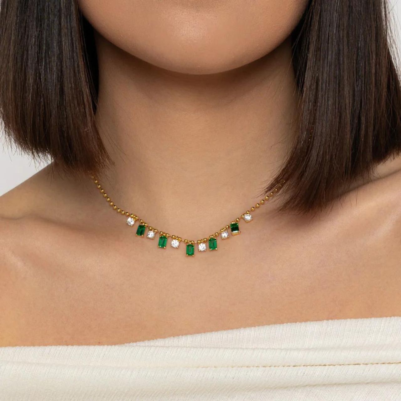 Elevate your style with the Emerie Gold Necklace from Knight &amp; Day. Made with green and CZ stones, this elegant necklace adds a touch of sophistication to any outfit. Perfect for day or night, enhance your look with this stunning accessory.