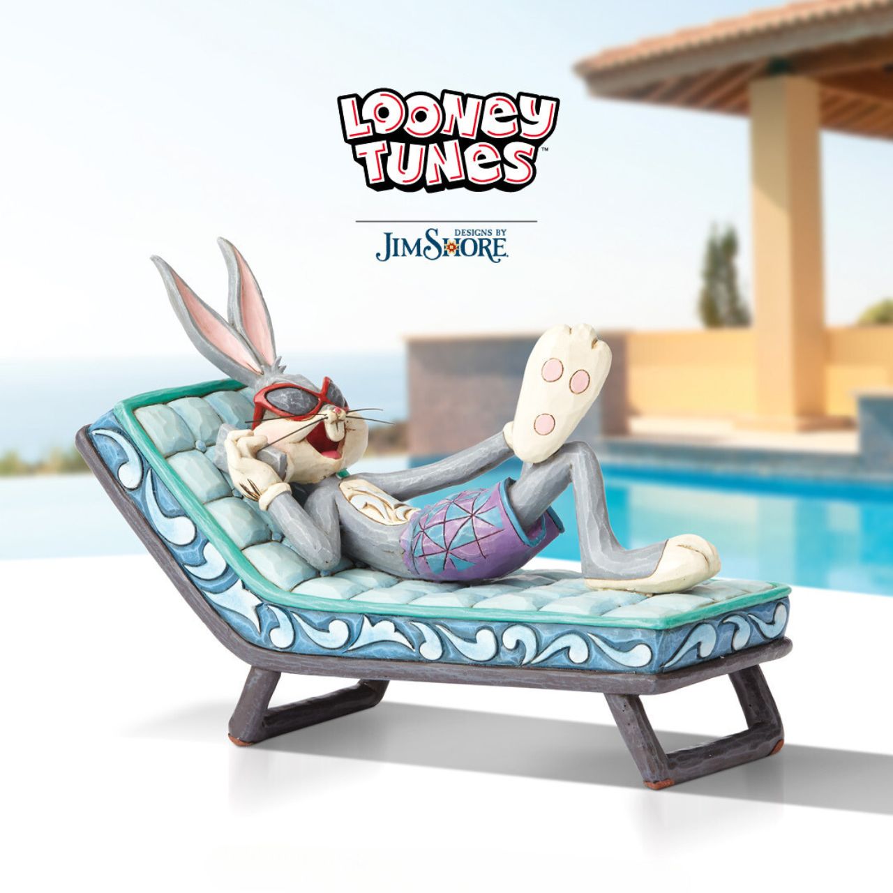 Movie mogul Bugs Bunny catches some rays in this whimsical scene from Looney Tunes. Handcrafted in rich detail, this poolside rabbit is beautifully decorated with the quilt patterns and folk-art style that are unmistakably Jim Shore.