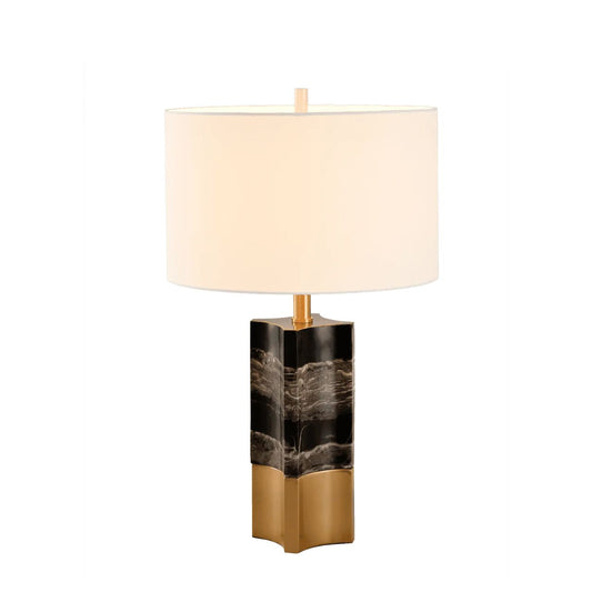 A show stopper. A unique marble base, a smooth finish, black and grey in colour with antique brass detail on the bottom of the lamp. Shape is not round which makes this lamp unique in is style. Curved styling seen on base of lamp. Beige lamp shade, cylinder in shape.