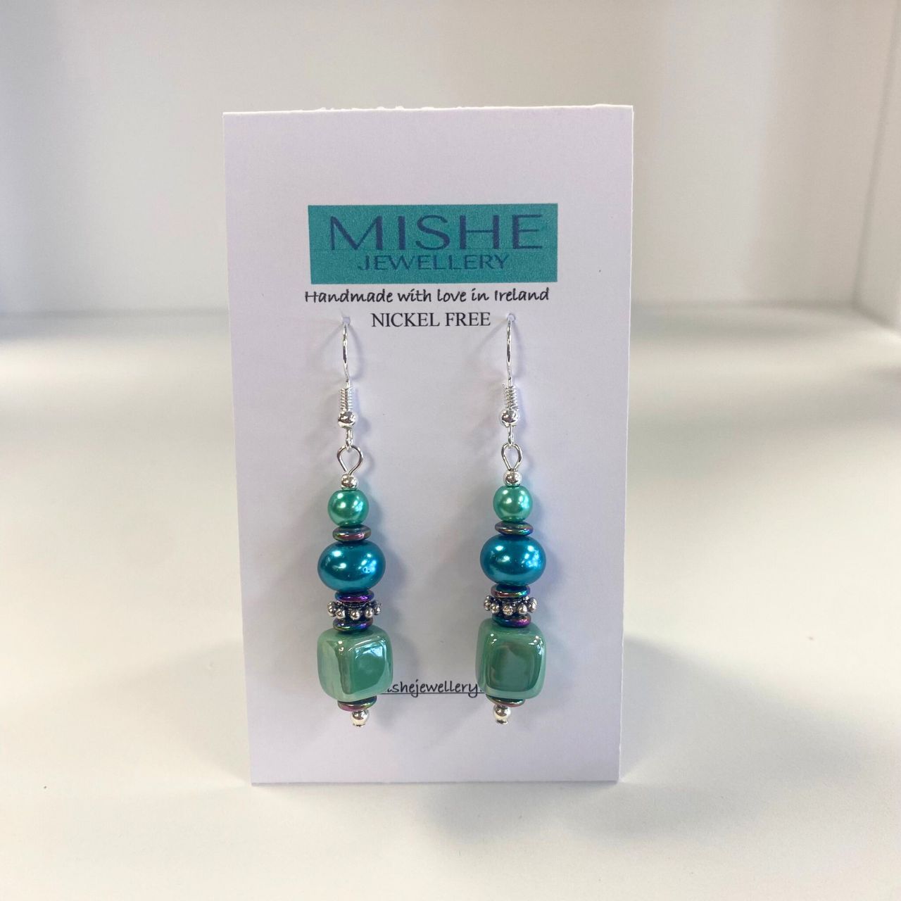 These attractive earrings combine handmade Ceramic Cubes in seagreen with turquoise Pearl Rondelles, tiny iridescent Hematite gemstone rondelles with decorative silver toned elements. Nickel free.