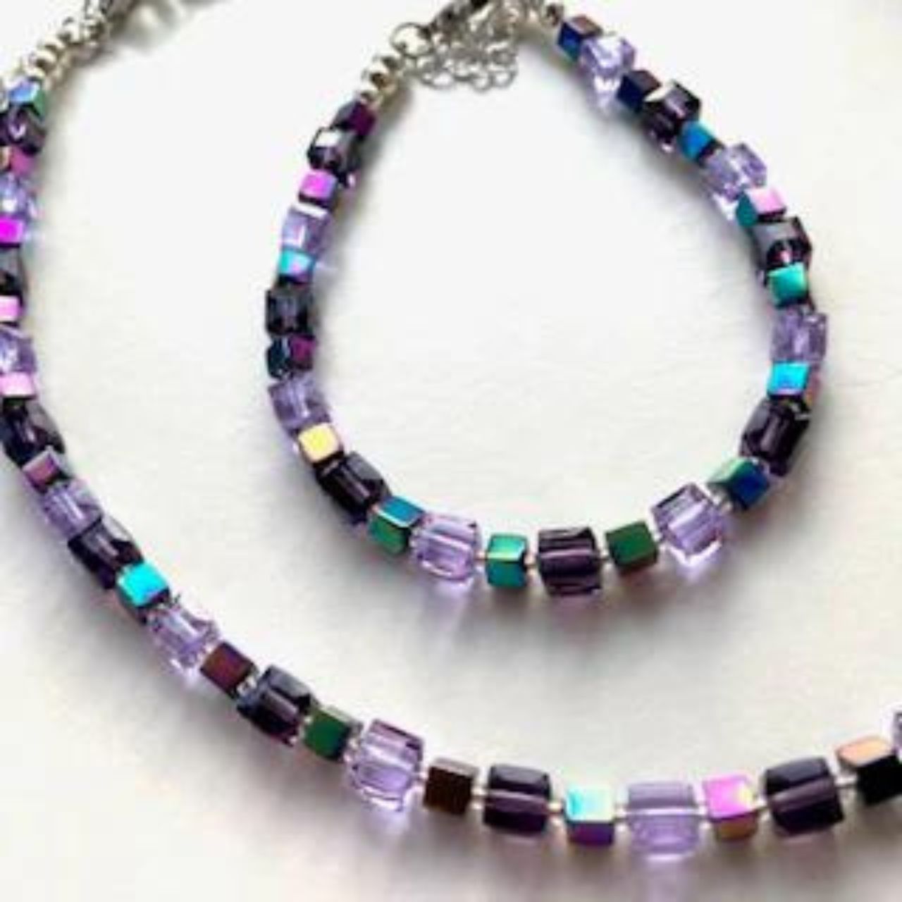 In this harmonious combination of purple hues, faceted Crystal Cubes in shades of purple and lilac are interspersed with iridescent Hematite gemstone Cubes in this light and pretty necklace.