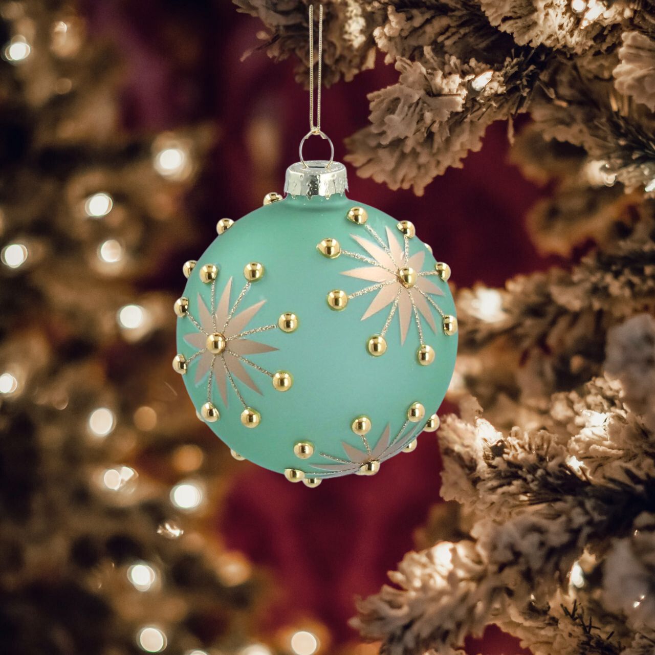 This Gisela Graham opaque green glass bauble is the perfect holiday decoration. Its intricate design features gold stars and beads to enhance its festive look. Ideal for any size tree, this bauble will add a touch of elegance and charm to your holiday décor.