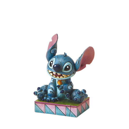 Designed by award winning artist and sculptor, Jim Shore for the Disney Traditions brand, this Stitch figurine is a part of a personality poses collection. He is featured displaying his typical mischievous smile. The figurine is made from cast stone.