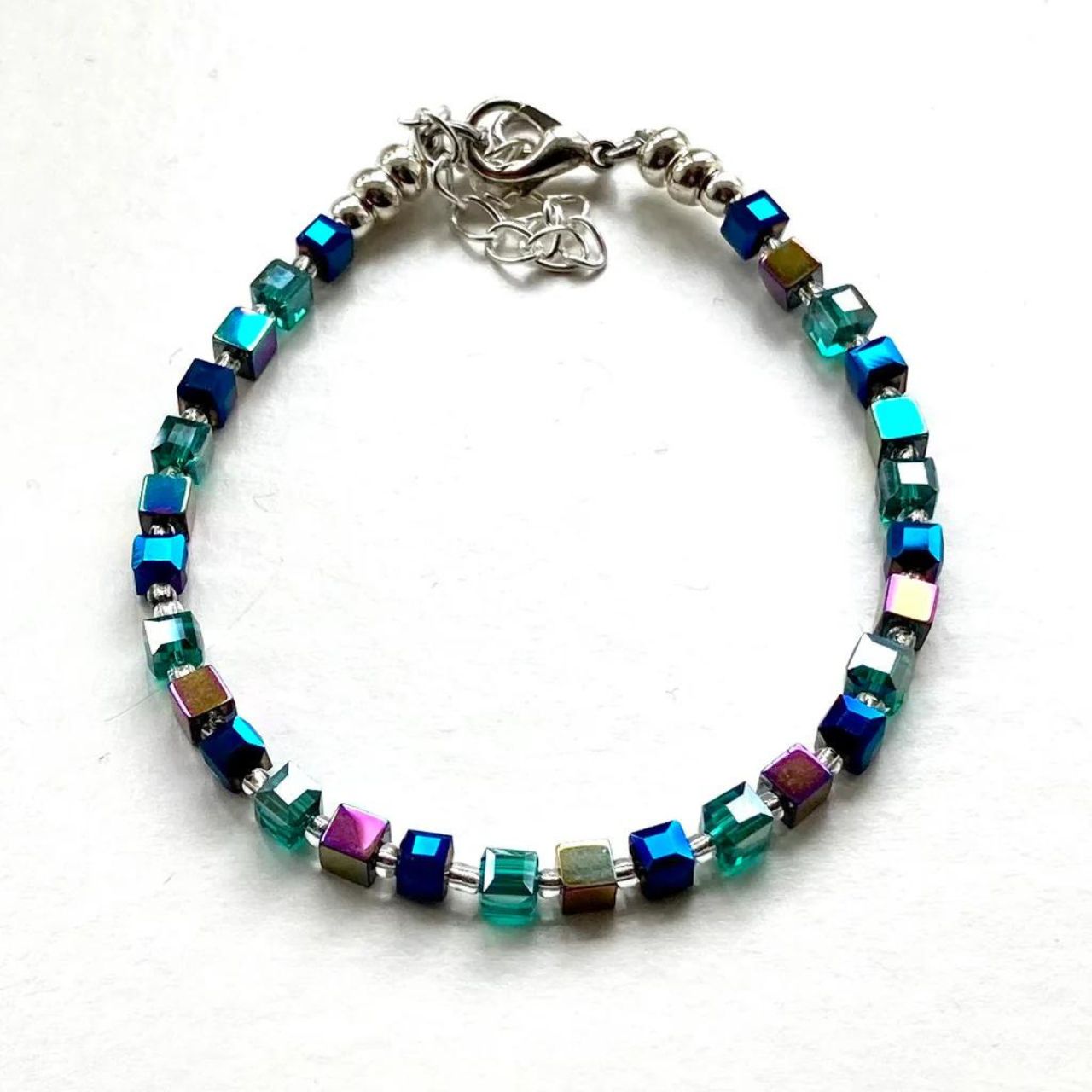 Teal and Blue Faceted Crystal cubes are teamed with purple/green Hematite gemstone cubes to create a vibrant colour combination.