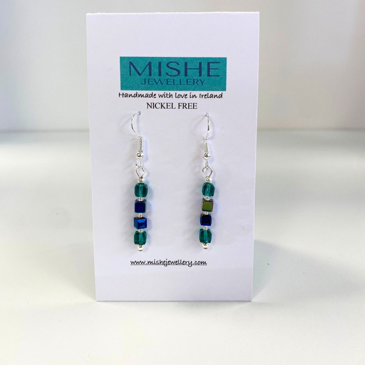 Faceted Crystal cubes in teal with an AB (Arora Borealis) finish coupled with blue Hematite and Blue faceted Crystal cubes. &nbsp;The earwires are nickel free silver plated.