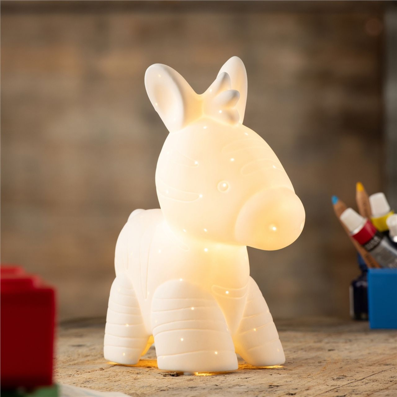 This quirky and fun zebra shaped luminaire emits a soft warm glow highlighting the delicate surface decoration and piercings, creating beautiful mood lighting for your home. Mains powered; light bulb included.