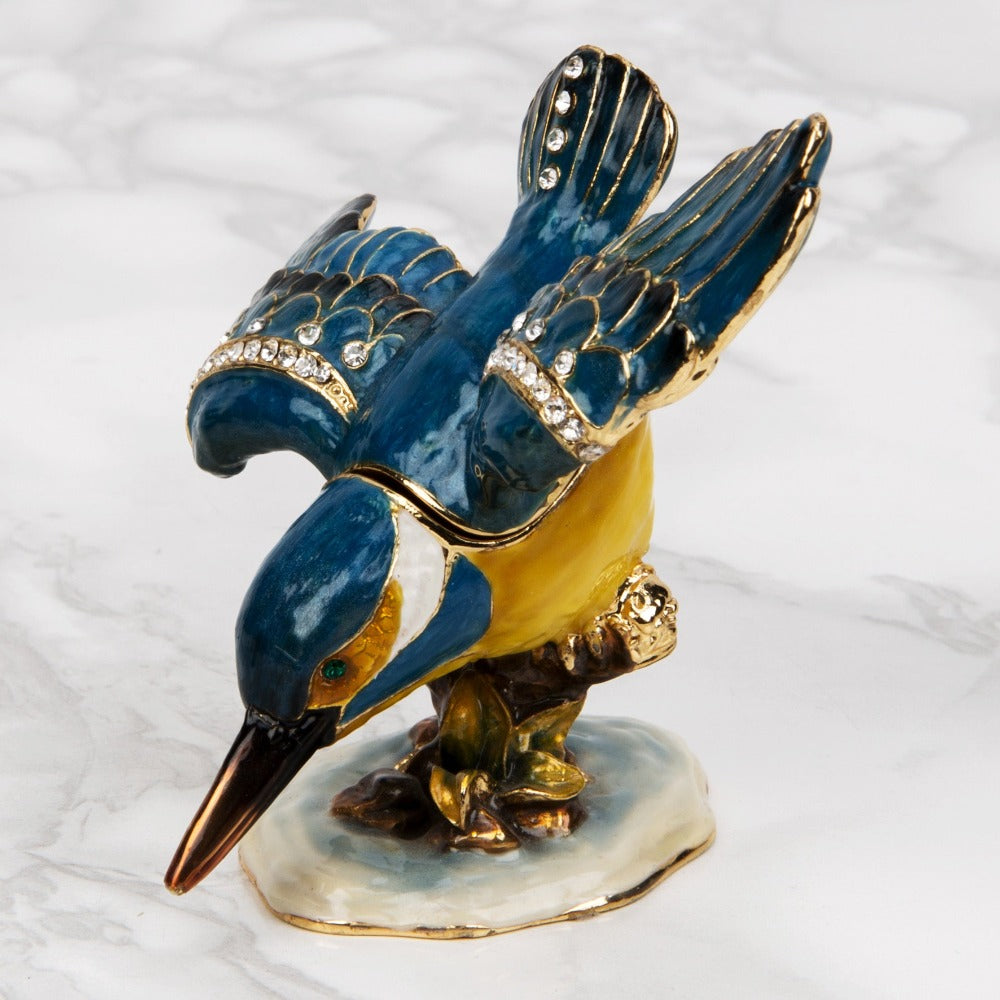 Treasured Trinkets Kingfisher  A beautiful, hand painted and crystal finished trinket box of a kingfisher hunting from Treasured Trinkets.  Painted in a gorgeous blue and gold colour, this trinket box is a wonderful ornament to complement a mantelpiece, bookcase or cabinet.